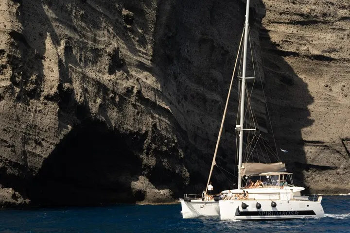 Luxury sailing catamaran near the Venetian Lighthouse on a Santorini catamaran cruise for small groups