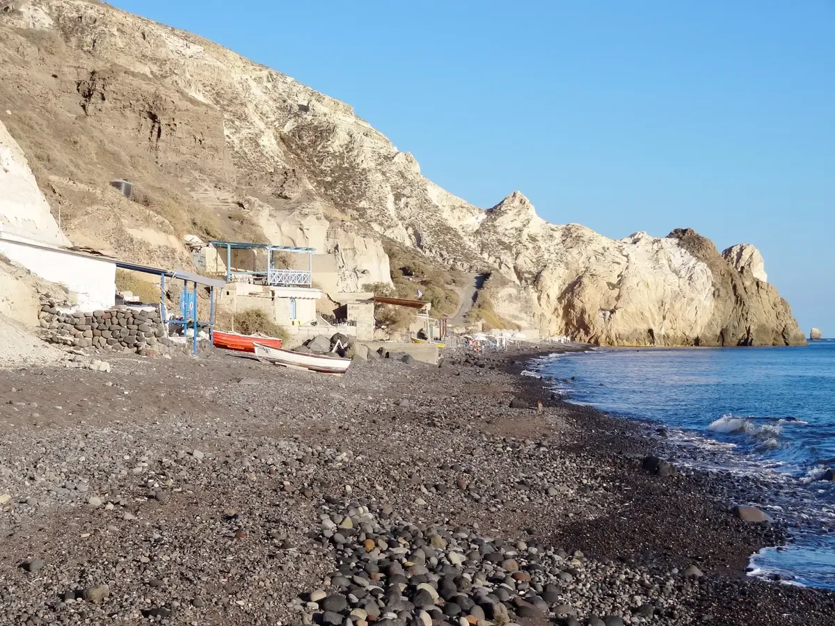 The black pebble beach of Mesa Pigadia, the BBQ stop of a Santorini catamaran cruise
