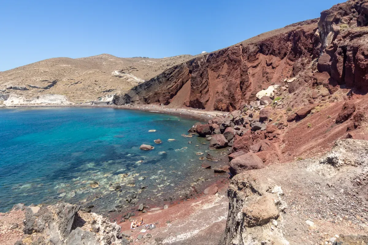 The rust-red cliffs of Red Beach, seen on every Santorini catamaran cruise