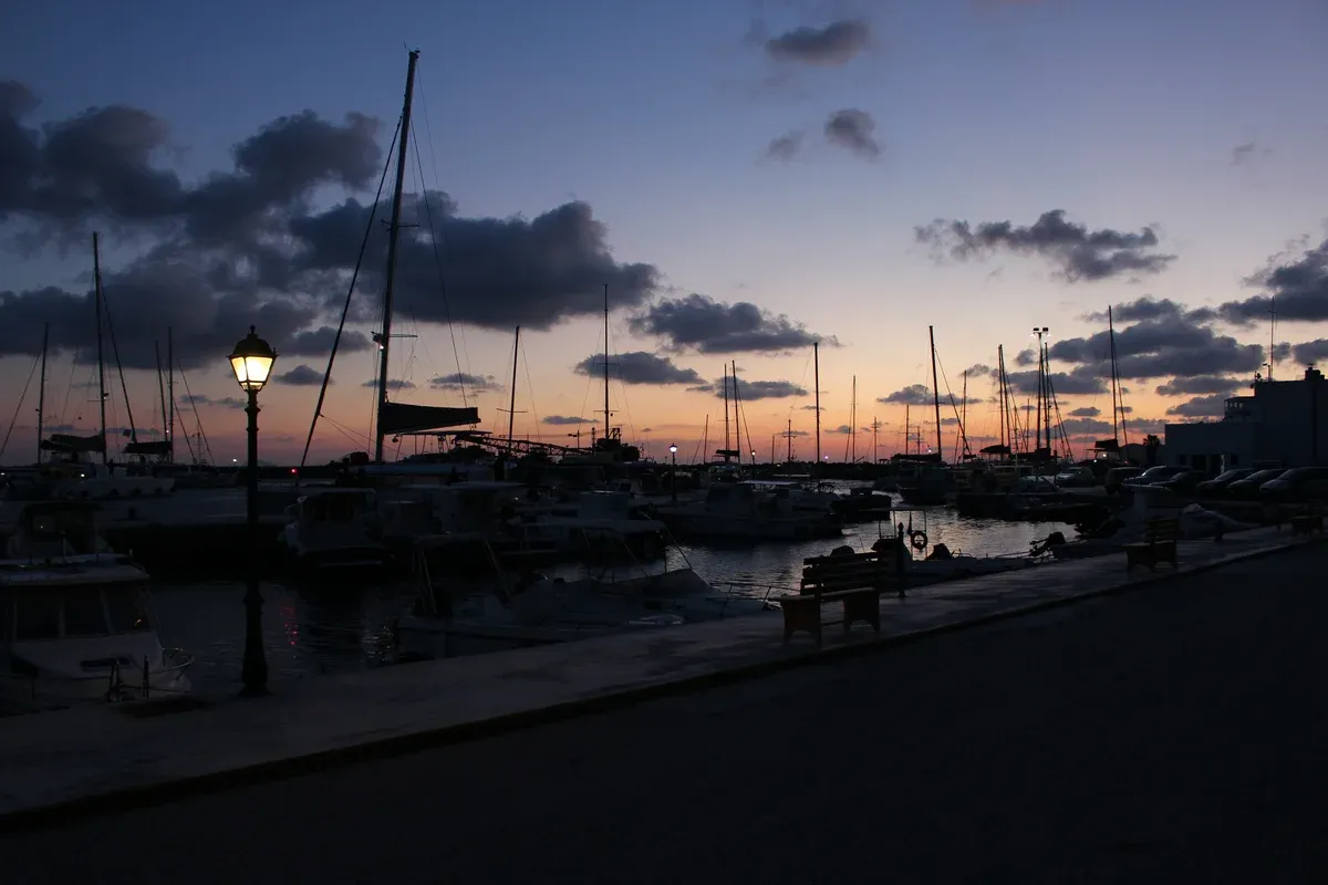 Vlychada marina at dusk with sailing boats moored, a departure point for Santorini catamaran cruises