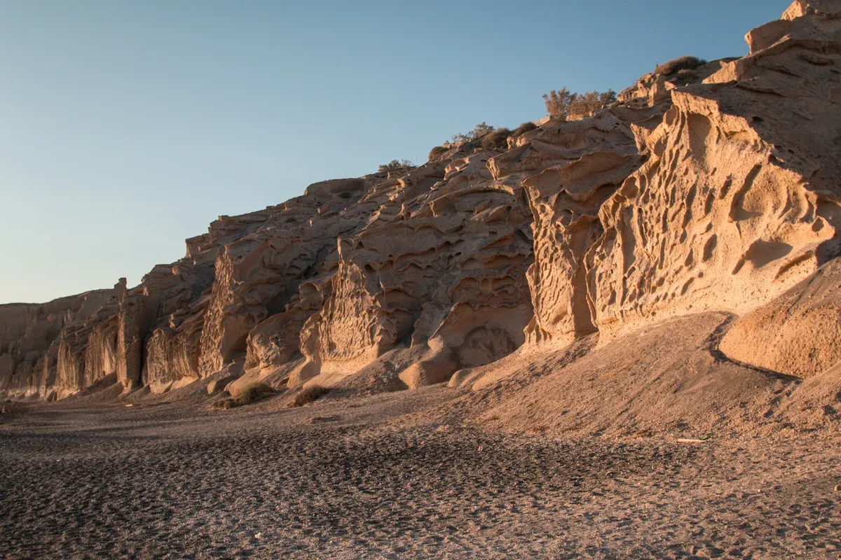 Eroded pumice cliffs at Vlychada beach on the south coast of Santorini on a Santorini catamaran cruise route