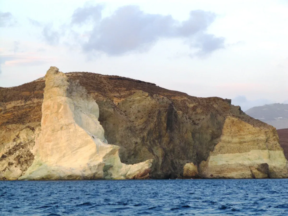 Pale pumice cliffs between White Beach and Red Beach, a stop on a Santorini catamaran cruise
